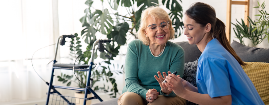 Life Assure Senior Woman Sitting In Chair And Laughing With Caregiver Nurse Hero